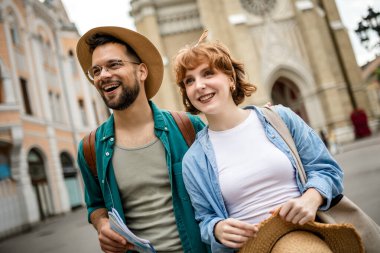 Genç bir çift yeni şehri gezmek için bir harita kullanıyor..