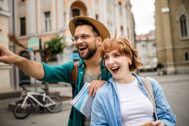 Genç bir çift yeni şehri gezmek için bir harita kullanıyor..