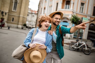 Genç bir çift yeni şehri gezmek için bir harita kullanıyor..