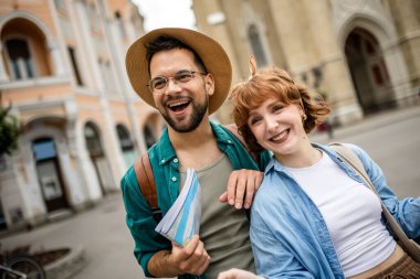 Genç bir çift yeni şehri gezmek için bir harita kullanıyor..
