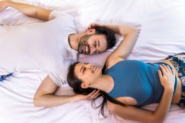 Çift yatağa uzanır ve birbirine bakar..