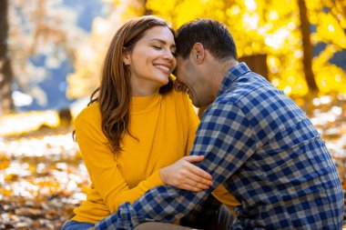 Birbirine aşık evli çiftler, sonbahar günü parkta piknik yaparken sarılırlar..