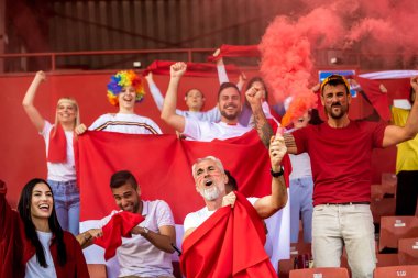 Spor taraftarları maçta stadyumda meşaleler yaktılar. Kırmızı renkler, bayraklar, stadyum.