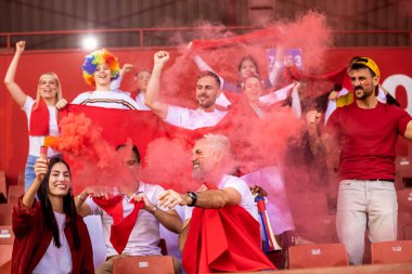 Spor taraftarları maçta stadyumda meşaleler yaktılar. Kırmızı renkler, bayraklar, stadyum.