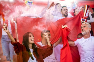 Spor taraftarları maçta stadyumda meşaleler yaktılar. Kırmızı renkler, bayraklar, stadyum.