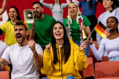 Alman futbolu ve futbol taraftarları stadyumda bayrak ve diğer ekipmanlarla tezahürat yapıyorlar.