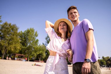 Genç çift güzel bir sahilde birlikte güzel vakit geçiriyorlar. Rahatlar, mutludurlar ve şu anda tamamen vardırlar.