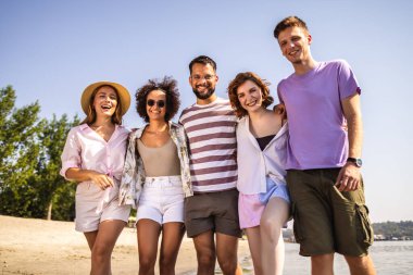 Beş genç arkadaştan oluşan bir grup kumsalda yürüyor, gülüyor ve deniz kenarında kaygısız bir günün tadını çıkarıyorlar.. 