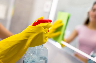 Banyo aynasını temizleme: kadın leke çıkarmak için bez kullanıyor.