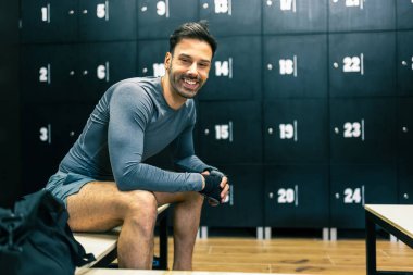Yakışıklı adam spor salonunun soyunma odasında çalışmaya hazırlanıyor..