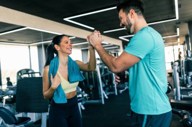 Spor salonunda iyi bir antrenmandan sonra iki fit insan beşlik çakar..