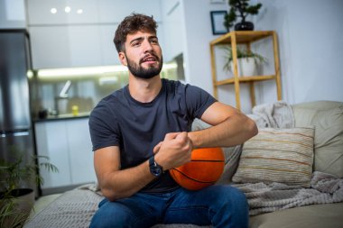 Genç bir adam evinde rahat bir şekilde oturuyor, oyun deneyimine dalmış, elinde bir kumanda, ve ekranın önüne odaklanmış.. 
