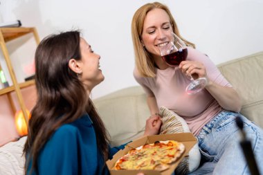 En iyi iki arkadaş birlikte eğlenceli ve rahat bir gece geçiriyorlar, oturma odasında pizza ve kırmızı şarapla oturuyorlar.. 