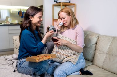 Sıcak bir yuva ortamında, biri hasta ve dinlenirken, diğeri dijital tablet tutarken, en iyi iki arkadaş yan yana oturur., 