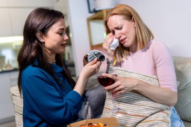 Sıcak bir yuva ortamında, biri hasta ve dinlenirken, diğeri dijital tablet tutarken, en iyi iki arkadaş yan yana oturur., 