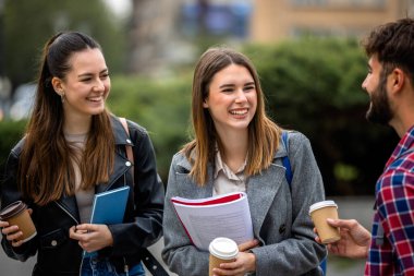 Güneşli bir günde üç üniversite öğrencisi dışarıda birlikte çalışıyor. Bir öğrenci kahve getirdi, çalışma seansına gelişigüzel bir dokunuş ekledi..
