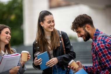 Güneşli bir günde üç üniversite öğrencisi dışarıda birlikte çalışıyor. Bir öğrenci kahve getirdi, çalışma seansına gelişigüzel bir dokunuş ekledi..