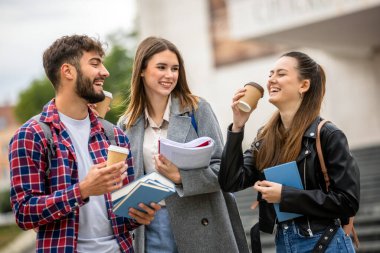 Güneşli bir günde üç üniversite öğrencisi dışarıda birlikte çalışıyor. Bir öğrenci kahve getirdi, çalışma seansına gelişigüzel bir dokunuş ekledi..