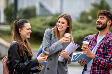 Güneşli bir günde üç üniversite öğrencisi dışarıda birlikte çalışıyor. Bir öğrenci kahve getirdi, çalışma seansına gelişigüzel bir dokunuş ekledi..