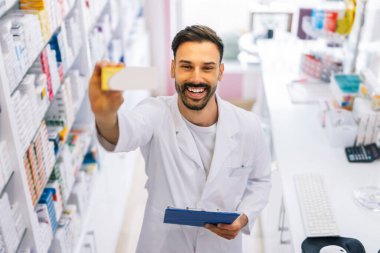 Eczanede elinde ilaç kutusu olan bir eczacının portresi..