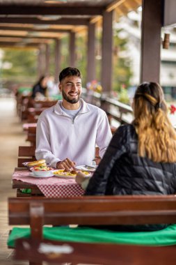 Dağlarda açık havada yemek yiyen çift.