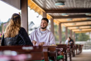 Dağlarda açık havada yemek yiyen çift.