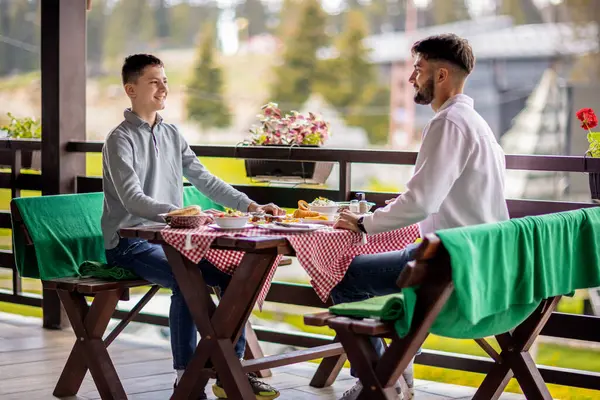 İki kardeş, taze bir bahar ya da renkli bir sonbahar gününde bir dağ restoranının terasında öğle yemeğinin tadını çıkarıyorlar.. 