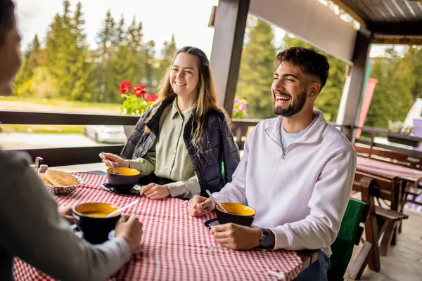 Erkek ve kız kardeşler açık bir bahar ya da sonbahar gününde bir dağ restoranının terasında öğle yemeği yiyorlar.. 