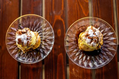 Teras masasında bir tabak kremalı profiterol.