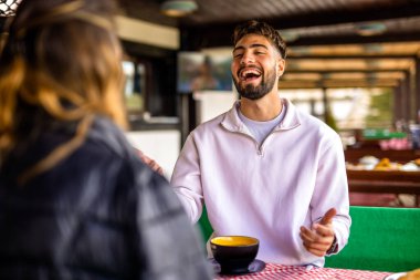 Genç çift, güneşli bir sonbahar ya da bahar günü birlikte bir dağ restoranının terasında öğle yemeği yiyorlar..