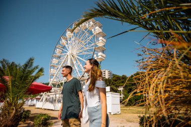 Sahilde romantik bir yaz gününün tadını çıkaran genç bir çift deniz kenarındaki bir lunaparkta dönme dolabın önünde dikiliyorlar. Işık ve yaz kıyafetleri giyip birbirlerine sevgiyle sarılıyorlar ve sohbet ediyorlar.. 