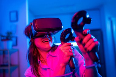 Genç bir kadın sanal gerçeklik oyun deneyimine kendini tamamen kaptırmış..