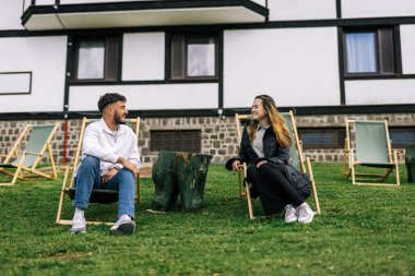 Genç bir çift, manzaralı bir dağ evinde huzurlu bir hafta sonu inzivasının tadını çıkarıyor. Şezlonglarda uzanmış, taze alp havasını emiyorlar..