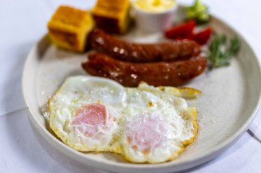 Çırpılmış yumurta, çıtır pastırma, taze domatesle servis edilmiş.