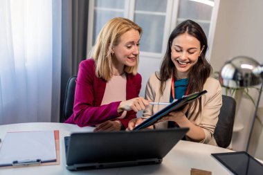 Kadın CEO, modern bir ofiste çalışan meslektaşlarına görevlerini anlatıyor, takım çalışması ve profesyonel işbirliği sergiliyor..