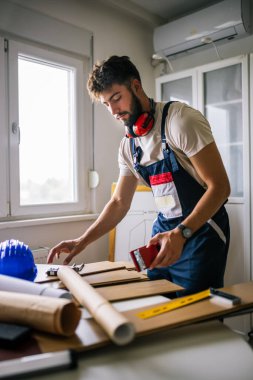 Tamirci dikkatlice dosyaları kaplatır, zemini titizlikle kaplar, güvenlik malzemesi giyer ve düzgün ve düzgün bir son için aletler kullanır..