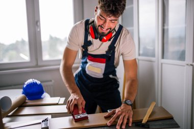 Tamirci dikkatlice dosyaları kaplatır, zemini titizlikle kaplar, güvenlik malzemesi giyer ve düzgün ve düzgün bir son için aletler kullanır..