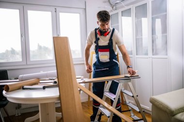Tamirci dikkatlice dosyaları kaplatır, zemini titizlikle kaplar, güvenlik malzemesi giyer ve düzgün ve düzgün bir son için aletler kullanır..