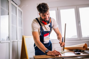 Tam teçhizatlı bir tamirci çekiçle bir dairede döşeme kaplaması, hassas kurulum ve yüksek kalitede işçiliği garantiliyor..