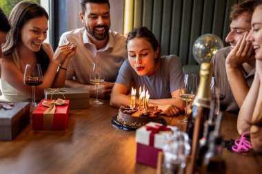 Arkadaşlar bir restoranda doğum gününü kutluyor, doğum günü kızı pastasına mumlar üflerken ve masada hediyelerle şarkı söyleyip alkışlıyorlar..
