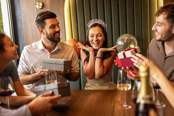 Arkadaşlar bir restoranda doğum gününü kutlarlar, doğum günü kızına hediyeler verirler, gülümsemelerini paylaşırlar, konuşurlar ve masada pastayla şarabın tadını çıkarırlar..