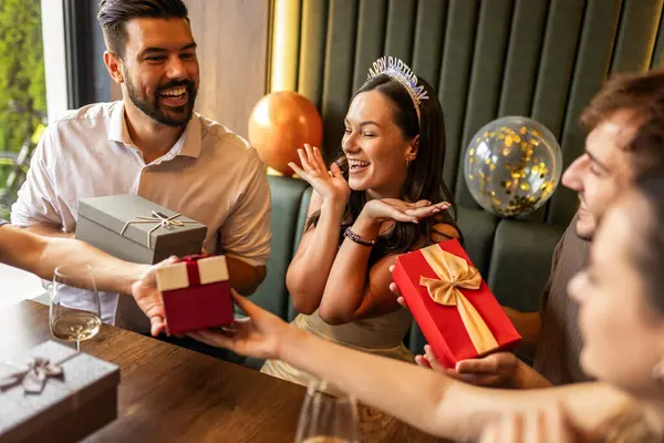 Arkadaşlar bir restoranda doğum gününü kutlarlar, doğum günü kızına hediyeler verirler, gülümsemelerini paylaşırlar, konuşurlar ve masada pastayla şarabın tadını çıkarırlar..