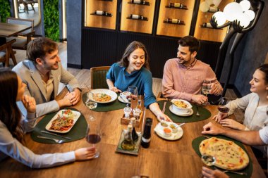 İş adamlarının pizza, makarna, pirinç, tavuk ve şarabın olduğu bir restoranda toplantı yapmalarının en iyi görüntüsü..