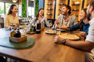 Restoranda pizza, makarna, tavuk, pilav yiyip sohbet ederken şarap içen bir grup iş arkadaşı..