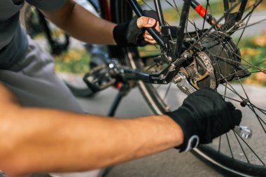 Genç adam bisiklet zincirini, bisiklet bakım, onarım, bisiklet, açık hava aktivitesi, kentsel hareketlilik, sağlıklı yaşam tarzı, bisiklet tamircisi konseptini tamir ediyor..