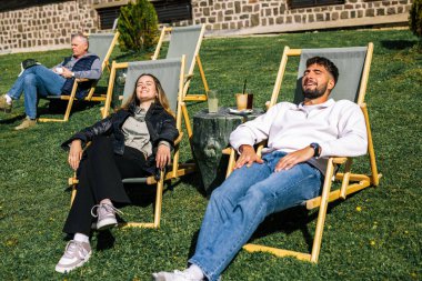 Mutlu genç çift güneşli bir günün tadını çıkarıyor, birlikte dinleniyor ve dışarıda huzurlu bir sonbahar anının tadını çıkarıyor..