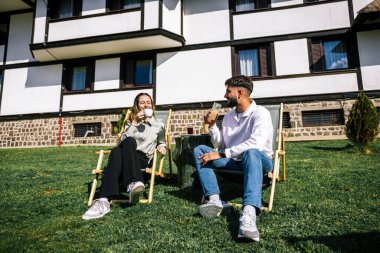 Genç çift dinlenme yerlerinde kahvelerini yudumluyor.