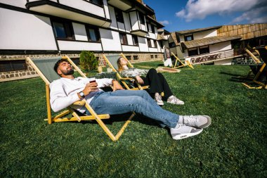 Mutlu genç çift güneşli bir günün tadını çıkarıyor, birlikte dinleniyor ve dışarıda huzurlu bir sonbahar anının tadını çıkarıyor..