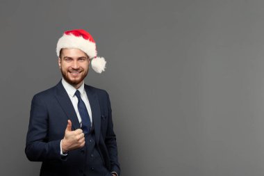 Yakışıklı iş adamının portresi takım elbise giyen başarılı bir iş adamı ve Noel şapkası..