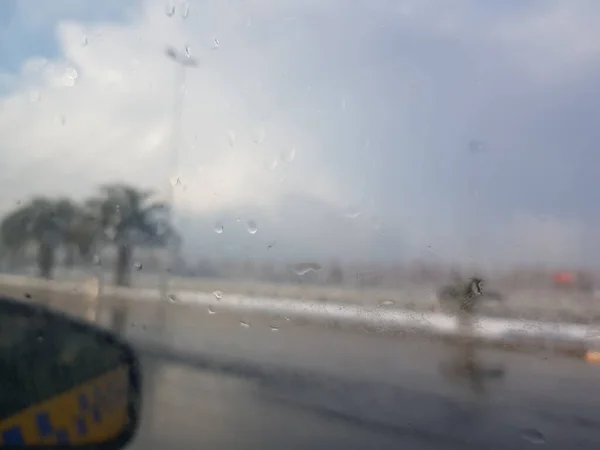 Krople Deszczu Szybę Samochodu Widokiem Zewnętrzne Lusterko Rozmyte Tło Palmami — Zdjęcie stockowe